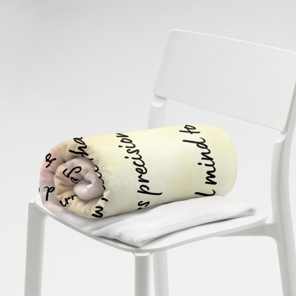 Folded fleece blanket featuring handwritten affirmation text in black script on a soft pastel background, displayed on a white chair.