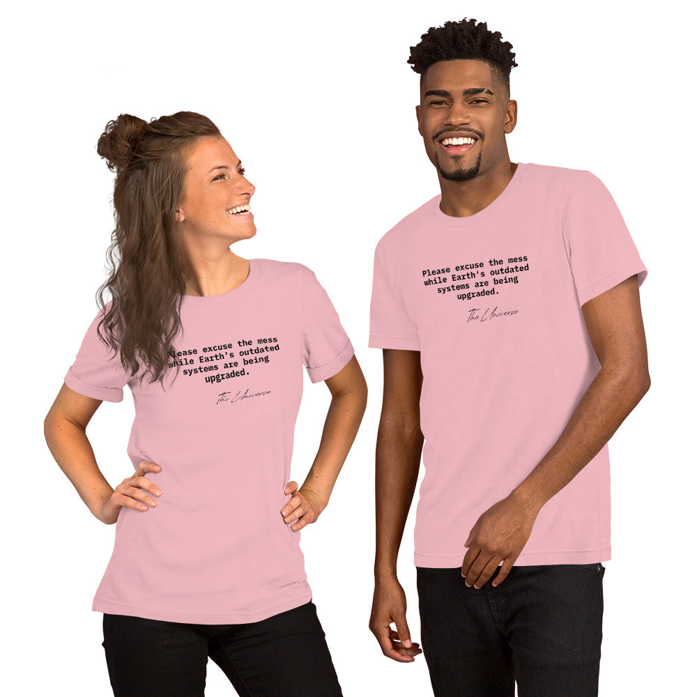 Pink unisex t-shirt featuring the phrase 'Please excuse the mess while Earth’s outdated systems are being upgraded.'