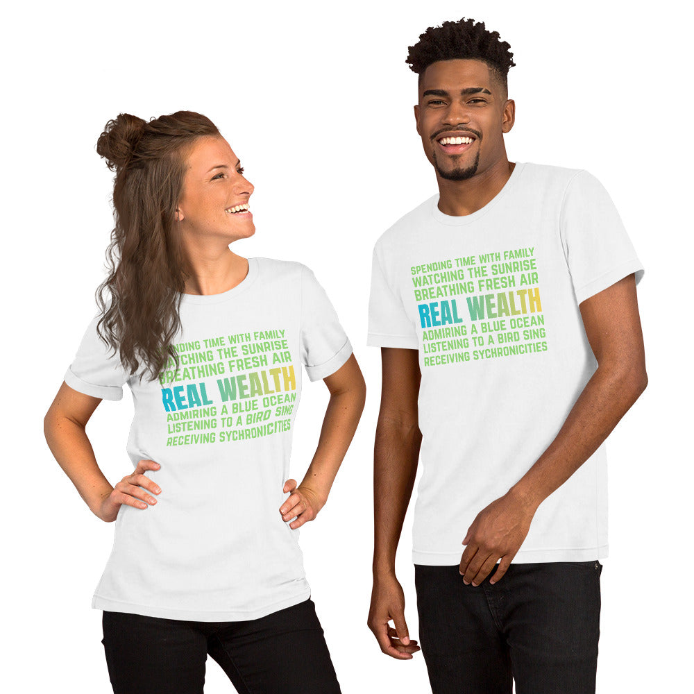 Unisex t-shirt featuring green and blue text reading “Real Wealth” with a list of lifestyle phrases.