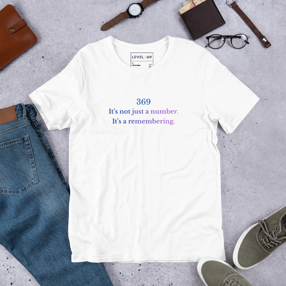 Flat lay of unisex t-shirt featuring the phrase ‘369 – It’s not just a number. It’s a remembering,’ in a soft blue-to-violet gradient.