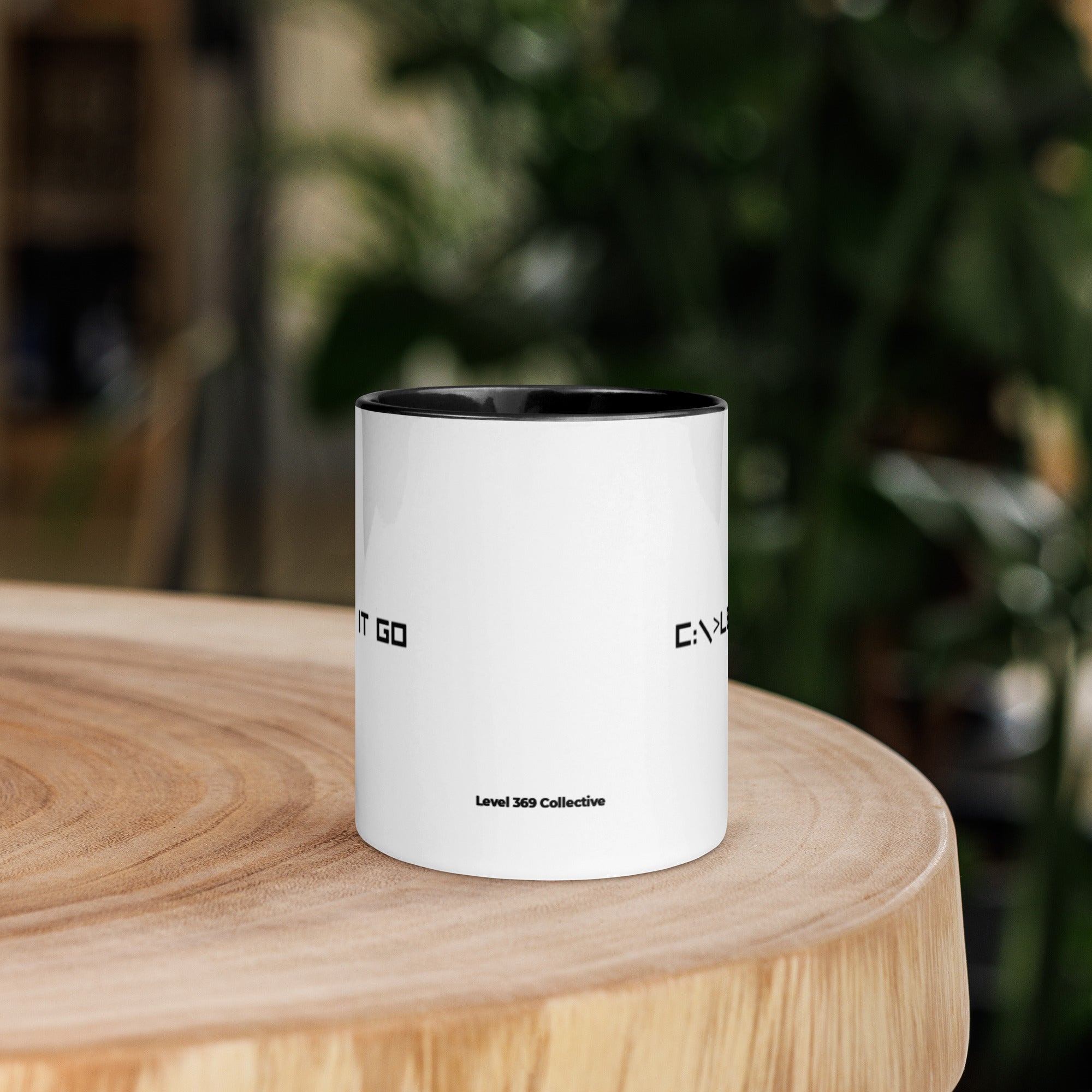 White ceramic mug showing back view with “Level 369 Collective” text and partial “let it go” design wrapping around
