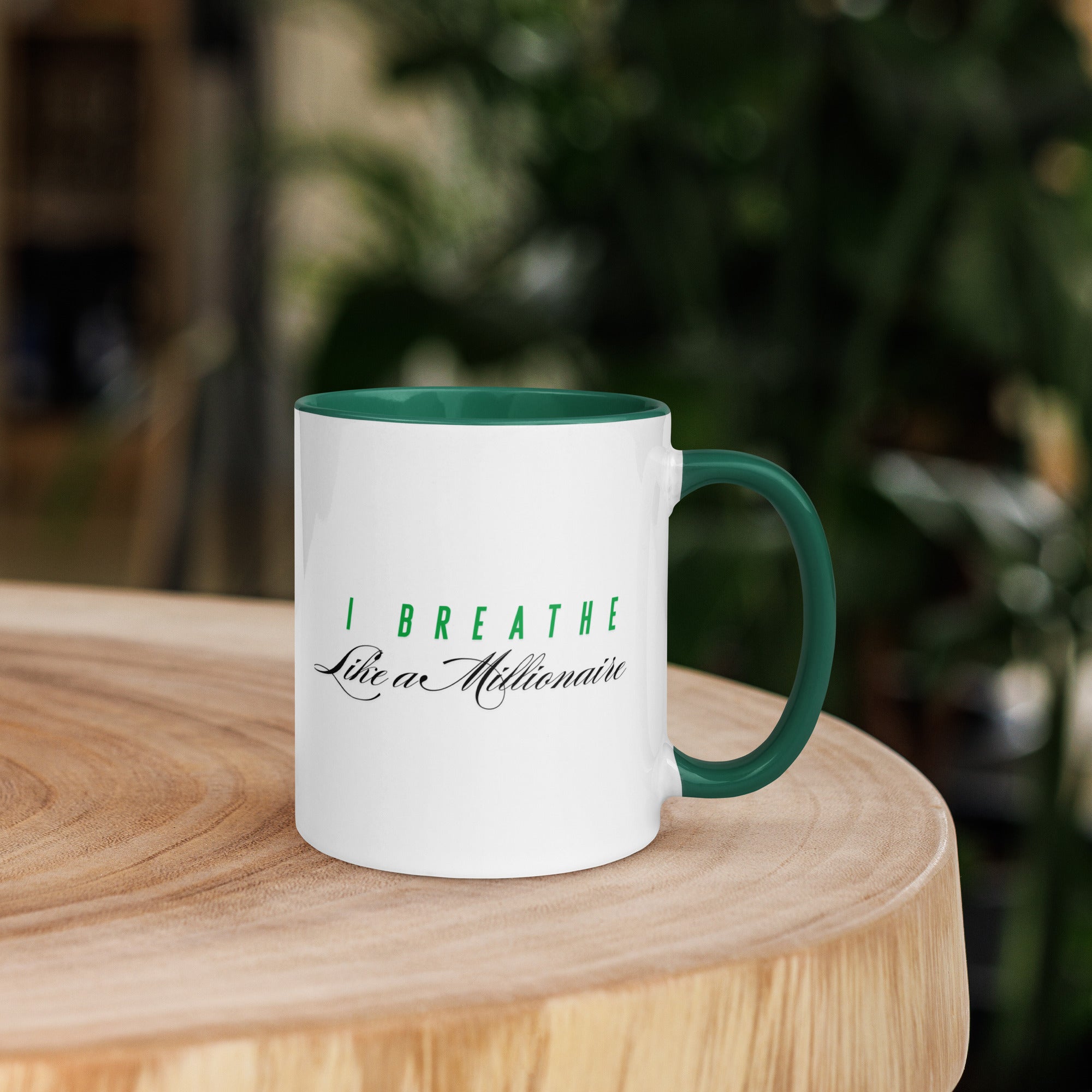 White ceramic mug with a green interior and handle, featuring the phrase "I Breathe Like a Millionaire."
