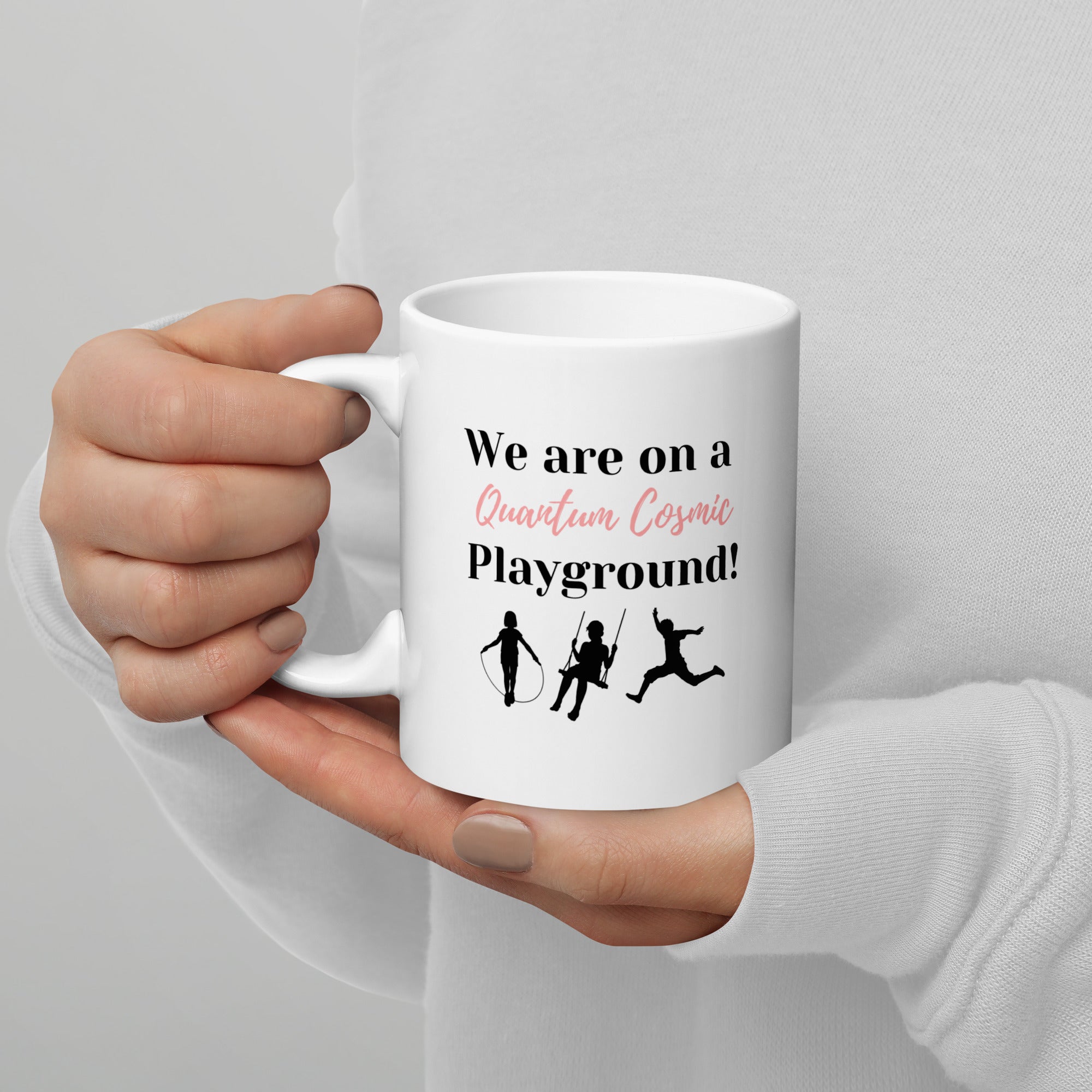 White ceramic mug with the phrase "We are on a Quantum Cosmic Playground."
