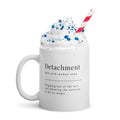 White ceramic mug featuring the word "Detachment."
